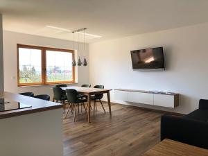 a living room with a table and chairs and a tv at Obst- und Ferienhof Fahr in Friedrichshafen