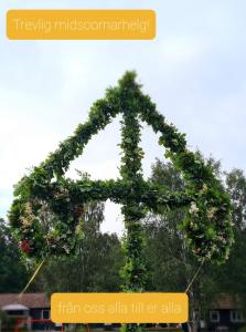 an arch covered in green ivy and flowers at Blankaholm 1:25 in Blankaholm