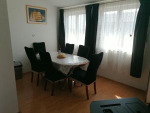 een eetkamer met een tafel, stoelen en ramen bij Tea in Povljana