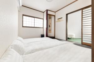 um quarto com duas camas e uma janela grande em Hotel kiki em Osaka
