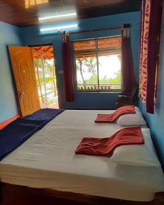 a bedroom with a large bed and a window at Niramaya beach view stay in Gokarna