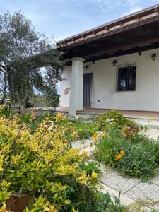 a garden in front of a house with flowers at Casa Corofulu Oliena - IUN P2139 in Oliena