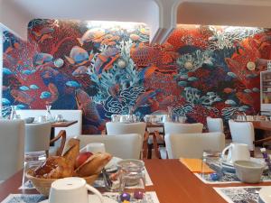 a dining room with a wall mural of fishes at Hôtel Ker-Noyal Quiberon Plage in Quiberon