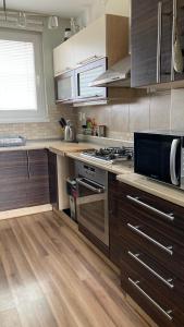 La cuisine est équipée de placards en bois et d'un four avec plaques de cuisson. dans l'établissement Apartment Safarikova, à Trnava