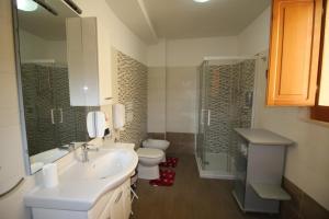 La salle de bains est pourvue d'un lavabo, de toilettes et d'une douche. dans l'établissement Casa di Luce LightHouse, à Reggio de Calabre
