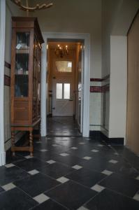 um corredor com piso xadrez preto e branco em B&B de Blauwververij em Blitterswijck