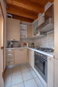 a kitchen with white cabinets and a stove top oven at Happy Guest Apartments - Lake & Relax in Riva di Solto