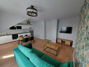 Marina Gdańsk في غدانسك: غرفة معيشة مع أريكة زرقاء ومطبخ