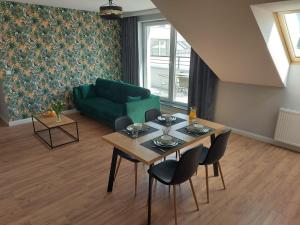 Marina Gdańsk في غدانسك: غرفة معيشة مع طاولة وأريكة خضراء