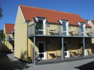 um edifício de apartamentos com cadeiras e uma varanda em Plesners Anneks em Skagen