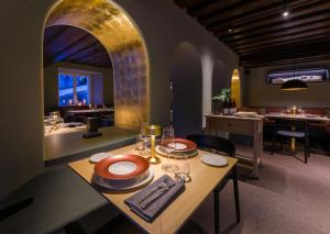 a dining room with a table with plates and glasses at Eibsee Hotel in Grainau