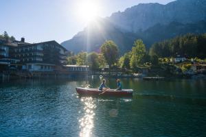 two people in a boat on a lake at Eibsee Hotel in Grainau