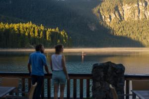 a man and woman standing on a dock overlooking a lake at Eibsee Hotel in Grainau