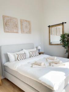Schlafzimmer mit einem großen weißen Bett und einem Spiegel in der Unterkunft Ferienwohnung Baltic Idyll in Scharbeutz