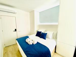 a bedroom with a large bed with blue and white pillows at Gloria 10 Deluxe in Lisbon
