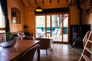 een woonkamer met een tafel en stoelen bij Charmante Cabane dans les arbres avec jacuzzi et sauna in Boismorand
