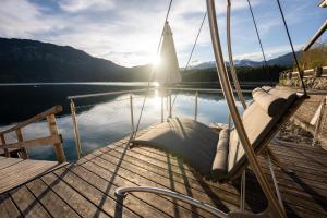 a boat with a hammock on a dock next to the water at Eibsee Hotel in Grainau