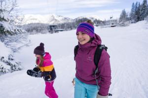 a woman and a child standing in the snow at Eibsee Hotel in Grainau