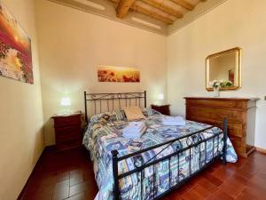 1 dormitorio con 1 cama, 2 mesitas de noche y espejo en La Torre di Caprera, en Siena