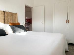 a bedroom with a white bed with white cabinets at DIANA BEACH HOUSE in Albufeira +21 photos