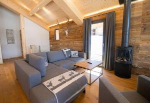 ein Wohnzimmer mit einem Sofa und einem Kamin in der Unterkunft Bergresort Hauser Kaibling by ALPS RESORTS in Haus im Ennstal