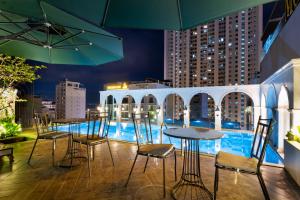 a patio with chairs and a table and a pool at Louis Mo Apartment in Da Nang