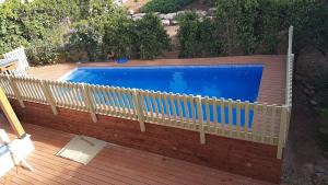a fence around a swimming pool on a wooden deck at Mango Tree Hut in Kefar H̱ittim