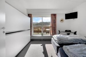 a room with two beds and a large window at Danhostel Vejle in Vejle