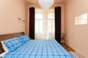 a bedroom with a bed with blue sheets and a window at Andrews Centre Apartment in Prague