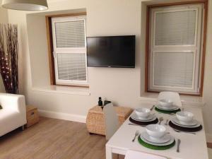 uma sala de estar com uma mesa branca e uma televisão em No.34 Apartment em Perth
