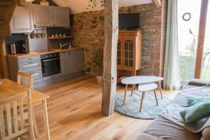 a living room with a table and a kitchen at À la Grange d'en Haut in Bras-Haut