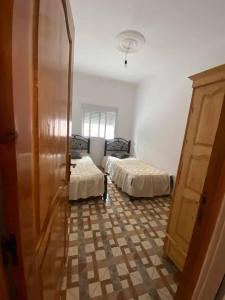 a room with two beds in a room with a closet at Appartement MARTIL BEACH 2 in Martil