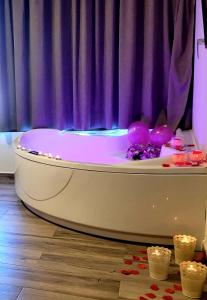 Casas del CerroCasas Rurales Maribel - Complejo Moradas del Cerro 1 - Suites con Jacuzzi en Alcalá del Júcar的客房内的白色浴缸配有紫色窗帘