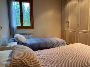 a bedroom with two beds and a window at Baketxe Baserria in Ziortza-Bolibar