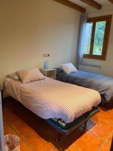 two beds sitting next to each other in a room at Baketxe Baserria in Ziortza-Bolibar