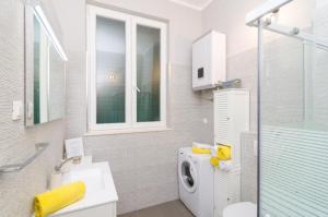 a bathroom with a washing machine and a sink at Apartman Mariva in Dubrovnik +11 photos
