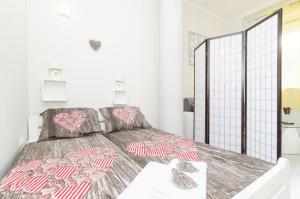 a bedroom with a bed with pink and gray comforter at Apartman Mariva in Dubrovnik