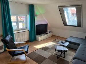een woonkamer met een bank en een tv bij FeWo HoLiDay HouSE Allgäu in Ottobeuren