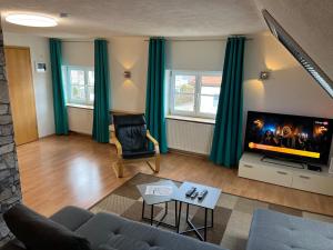 een woonkamer met een bank en een flatscreen-tv bij FeWo HoLiDay HouSE Allgäu in Ottobeuren