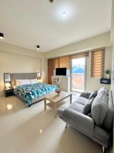 - une chambre avec un lit, un canapé et une télévision dans l'établissement Luxury Hotel Type Condo near NAIA Manila Airport, à Manille