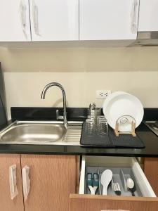 a kitchen counter with a sink and a plate and utensils at Luxury Hotel Type Condo near NAIA Manila Airport in Manila