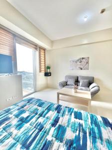 - une chambre avec un lit, un canapé et une fenêtre dans l'établissement Luxury Hotel Type Condo near NAIA Manila Airport, à Manille