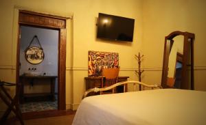 a bedroom with a bed and a television on the wall at La Casa del General Hotel Boutique in Hidalgo del Parral
