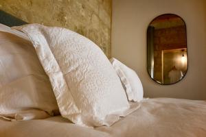 1 cama con almohadas blancas y espejo en NUMRU 27 Expertly restored small house of character, en Cospicua