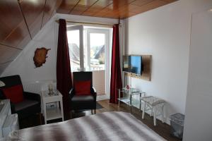 a bedroom with a bed and a tv and a window at Gästehaus Gudrun in Tönning