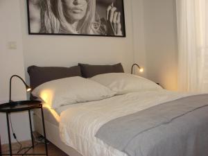 a bed in a bedroom with a picture on the wall at ACCI Cannes Croisette in Cannes