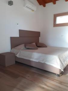 a bed in a bedroom with a wooden floor at Ex Cinquantadue in Pasiano di Pordenone