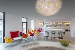 a lobby with colorful chairs and a large chandelier at Hotel City Lugano in Lugano