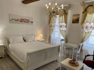 Un dormitorio con una cama grande y una lámpara de araña. en Maison du Cloitre Couvent des Carmes, en Narbona