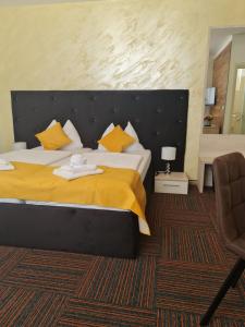 a bedroom with a large bed with a yellow blanket at Hotel Bor in Krk